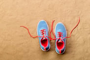 graphicstock-blue-sports-shoes-with-pink-shoelaces-laid-on-sand-beach-background-studio-shot-flat-lay-copy-space_BOGIso9UfW (1)