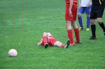 graphicstock-injured-player-at-the-football-match-lying-on-the-grass_SOIL5mVd-